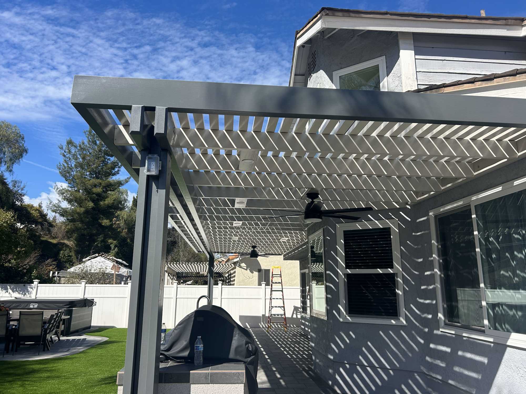 Weatherwood aluminum patio cover with white lattice, lights, and fans in Yorba Linda California
