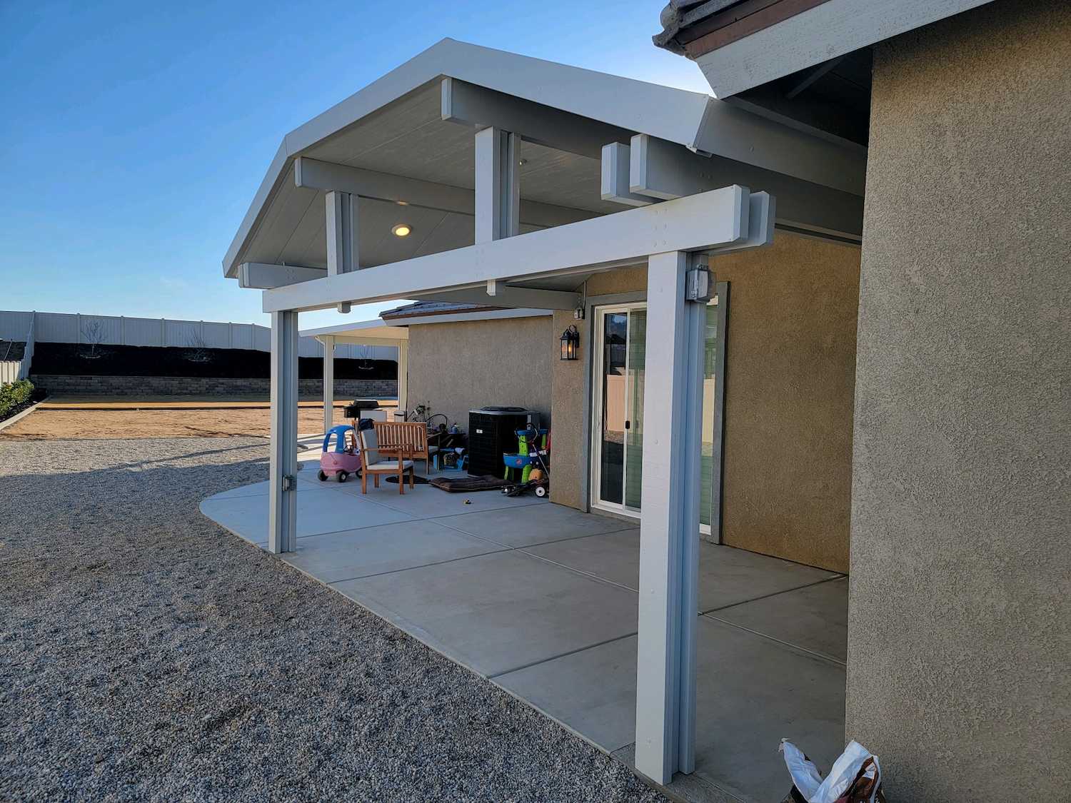 White insulated aluminum patio cover with integrated lighting attached to a home